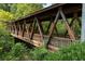 Exterior shot of a quaint wooden walking bridge with steel supports surrounded by lush green foliage and trees at 2010 Riverside Rd, Roswell, GA 30076