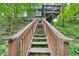 Long wooden staircase leading to the back of house with raised deck, surrounded by trees at 4772 Ridgewood Nw Ct, Acworth, GA 30102