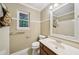 Bright bathroom featuring beadboard paneling, white fixtures, and a framed mirror at 4772 Ridgewood Nw Ct, Acworth, GA 30102