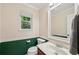 Cozy bathroom with green wainscoting, a classic vanity, and a bright window at 4772 Ridgewood Nw Ct, Acworth, GA 30102