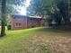 A spacious backyard featuring a brick house, a wooden deck and a lush green lawn at 5607 Mountainbrooke Ct, Stone Mountain, GA 30087