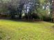 Large backyard area featuring a lawn and trees at 5607 Mountainbrooke Ct, Stone Mountain, GA 30087