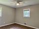 This bedroom features hardwood floors, neutral walls, a ceiling fan, and a bright window at 5607 Mountainbrooke Ct, Stone Mountain, GA 30087