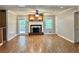 Spacious living room with hardwood floors, brick fireplace, and natural light from large windows at 5607 Mountainbrooke Ct, Stone Mountain, GA 30087