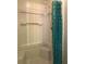 White shower stall with built-in seat and patterned blue curtain at 5607 Mountainbrooke Ct, Stone Mountain, GA 30087