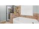 Bathroom featuring a tub and glass enclosed shower with neutral tile surround at 572 Boulder View Pkwy, Dallas, GA 30157