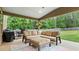 Comfortable covered patio with outdoor seating, area rug and beautiful backyard view at 572 Boulder View Pkwy, Dallas, GA 30157