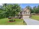 Charming two-story home featuring a manicured lawn, mature tree, and inviting front porch at 572 Boulder View Pkwy, Dallas, GA 30157
