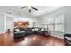 Open-concept living area showcasing hardwood floors and a comfortable gray sectional sofa next to the kitchen at 572 Boulder View Pkwy, Dallas, GA 30157