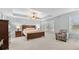 This main bedroom features a tray ceiling, ceiling fan, and carpet at 572 Boulder View Pkwy, Dallas, GA 30157
