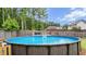 Outdoor above ground swimming pool with deck and a wooded surrounding area at 572 Boulder View Pkwy, Dallas, GA 30157