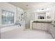 Bright bathroom features a soaking tub next to a beautiful glass shower, and vanity with a large mirror at 2112 Murren Se Dr, Smyrna, GA 30080