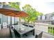 This outdoor deck includes a table with seating and an umbrella with a view of the detached garage at 2112 Murren Se Dr, Smyrna, GA 30080