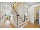 Bright entryway features hardwood floors, a staircase with white railings, and access to the living room and bathroom at 2112 Murren Se Dr, Smyrna, GA 30080