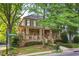 Charming two-story home with a welcoming front porch, stone accents, well-manicured lawn, and beautiful landscaping at 2112 Murren Se Dr, Smyrna, GA 30080