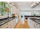 White kitchen features stainless appliances, black granite, hardwood flooring, and breakfast bar looking into the living room at 2112 Murren Se Dr, Smyrna, GA 30080