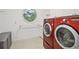 Laundry room boasts a round window, red front-loading washer and dryer, and plenty of storage space at 2112 Murren Se Dr, Smyrna, GA 30080