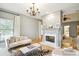 Open living room featuring a white sofa set, fireplace, hardwood floors, and a decorative chandelier at 2112 Murren Se Dr, Smyrna, GA 30080