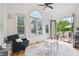Sunroom features large windows, hardwood floors, a ceiling fan, a comfortable chair and views of the private backyard at 2112 Murren Se Dr, Smyrna, GA 30080