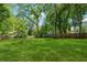 Expansive backyard featuring lush green grass and surrounded by mature trees and a wooden fence at 642 Erin Sw Ave, Atlanta, GA 30310