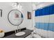 Bathroom with a dark countertop, toilet, shower, and round mirror above the sink at 642 Erin Sw Ave, Atlanta, GA 30310