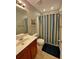 Bright bathroom with vanity and mirror, along with a shower and bathtub featuring a striped curtain at 125 Redsage Rdg, Atlanta, GA 30349