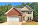 Charming home featuring a brick facade, neutral siding, well-manicured landscaping, and an attached two-car garage at 125 Redsage Rdg, Atlanta, GA 30349