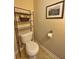 Cozy half-bathroom featuring a toilet, stylish tile flooring, and decorative wall art at 125 Redsage Rdg, Atlanta, GA 30349