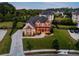 Beautiful aerial view of a home featuring a stone facade, manicured landscaping, and an expansive lawn at 1835 Henley Way, Alpharetta, GA 30009