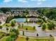 Aerial view of the community with a pool, tennis courts and houses surrounded by lush landscaping and mature trees at 1835 Henley Way, Alpharetta, GA 30009
