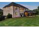 The brick home's rear elevation shows a covered patio and large lawn at 1835 Henley Way, Alpharetta, GA 30009