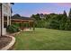 Large, lush green backyard with covered outdoor patio featuring an outdoor seating area at 1835 Henley Way, Alpharetta, GA 30009