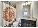 Well-lit bathroom with a decorative shower curtain and granite countertop vanity at 1835 Henley Way, Alpharetta, GA 30009