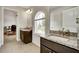 Bathroom with dark wood cabinets, granite countertop and a view to an adjoining room at 1835 Henley Way, Alpharetta, GA 30009