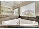 Bathroom featuring a triangular tub and tile surround with a window providing natural light at 1835 Henley Way, Alpharetta, GA 30009