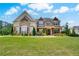 Charming stone home featuring an expansive lawn, manicured landscaping, and a welcoming front entrance at 1835 Henley Way, Alpharetta, GA 30009