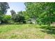 Spacious backyard featuring lush greenery surrounding the exterior of this charming single-story home at 2155 Rosedale Rd, Snellville, GA 30078