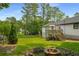 A serene backyard boasts mature trees, a fire pit, and a spacious lawn at 117 Franklin Rd, Woodstock, GA 30188