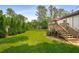 A lush green backyard features a deck and mature trees at 117 Franklin Rd, Woodstock, GA 30188