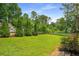 Lush backyard featuring mature trees and meticulously maintained landscaping at 117 Franklin Rd, Woodstock, GA 30188
