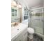 Bathroom featuring a single sink vanity, toilet and glass door shower with pebble accents at 117 Franklin Rd, Woodstock, GA 30188
