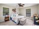Carpeted bedroom with ceiling fan, two windows, neutral walls, and queen bed with quilted blanket at 117 Franklin Rd, Woodstock, GA 30188