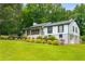 Well-kept home with front porch and attached garage nestled among mature trees at 117 Franklin Rd, Woodstock, GA 30188