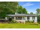 Charming home featuring a front porch and landscaped yard with mature trees at 117 Franklin Rd, Woodstock, GA 30188