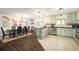 Bright kitchen with light green cabinets, stainless appliances and black countertops at 117 Franklin Rd, Woodstock, GA 30188