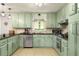Well-lit kitchen features stainless steel appliances and light green cabinetry at 117 Franklin Rd, Woodstock, GA 30188