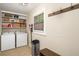 The laundry room has a side by side washer and dryer, as well as shelving at 117 Franklin Rd, Woodstock, GA 30188