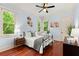 Light and airy bedroom with hardwood floors, two windows, light blue walls and a ceiling fan at 4105 Cougar Ne Pt, Marietta, GA 30066