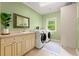 Bright laundry room with modern appliances, a sink, cabinets, and a window overlooking the lush greenery at 4105 Cougar Ne Pt, Marietta, GA 30066