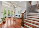 Open living room with a staircase, coffered ceiling, hardwood floors and large windows offering backyard views at 4105 Cougar Ne Pt, Marietta, GA 30066